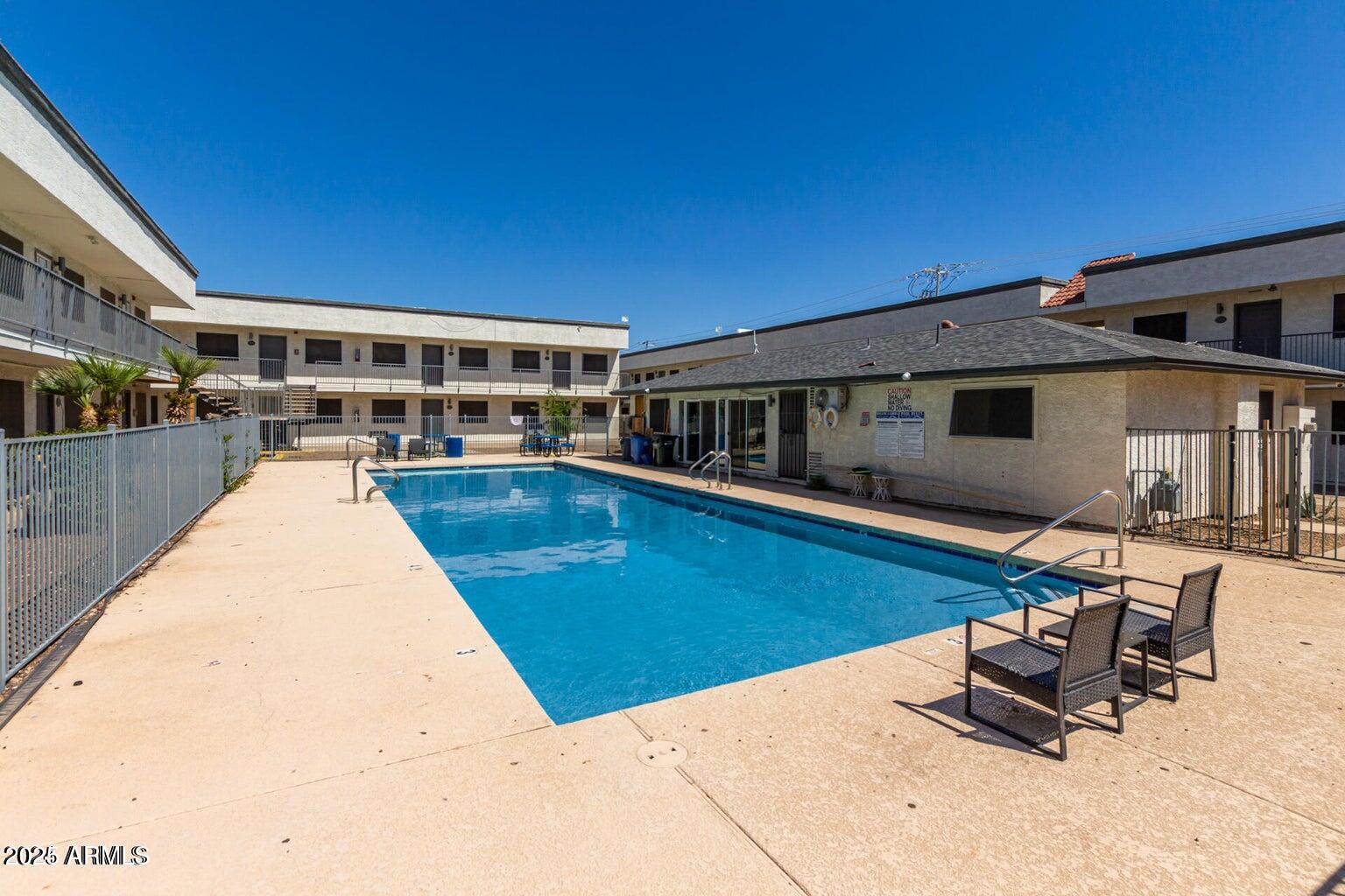18202 North Cave Creek Road, Unit 134 Phoenix, AZ 85032 - Photo 5 of 10 a view of a swimming pool with chairs