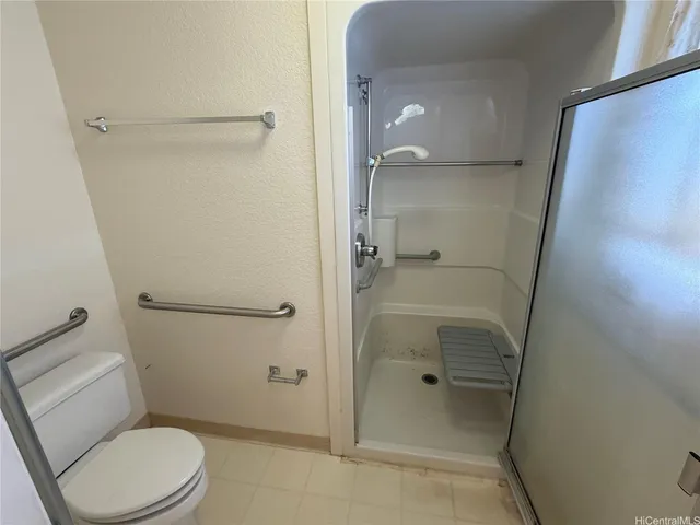 a bathroom with a granite countertop toilet a sink and shower