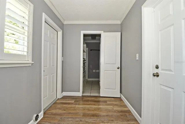 a view of an empty room with window and wooden floor