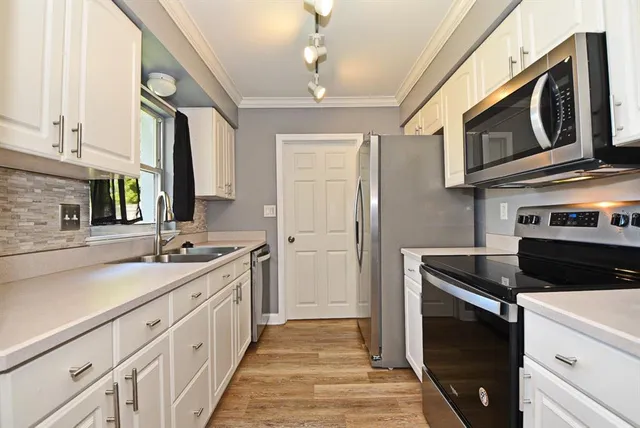 a kitchen with stainless steel appliances granite countertop a sink and a stove