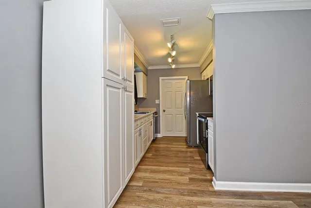 a view of a hallway with wooden floor and staircase