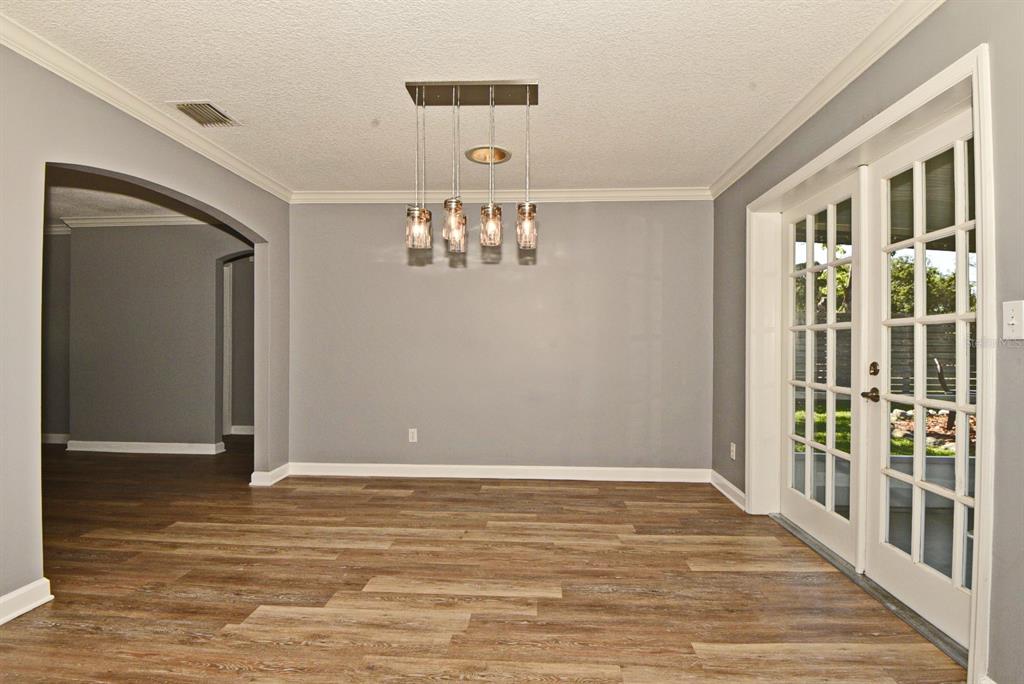 2717 Scarlet Road Winter Park, FL 32792 - Photo 9 of 31 a view of a hallway with wooden floor and a chandelier