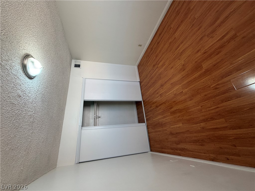 2236 East Desert Inn Road Las Vegas, NV 89169 - Photo 17 of 34 A clever built-in storage unit complements rich wood flooring and crisp white walls.