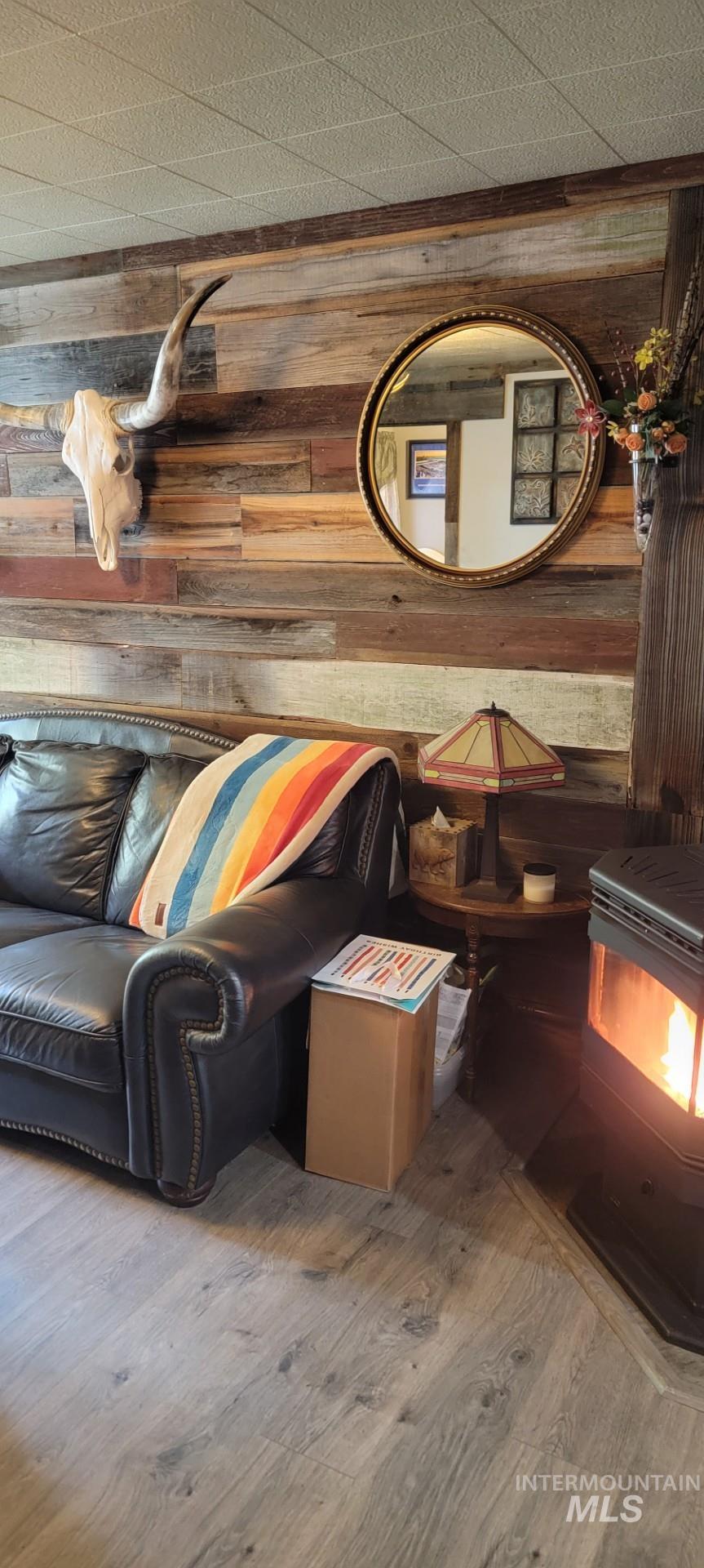 1006 Borah Avenue Riggins, ID 83549 - Photo 8 of 24 Living room. Detailed view of wooden walls, a wood stove, and wood finished floors