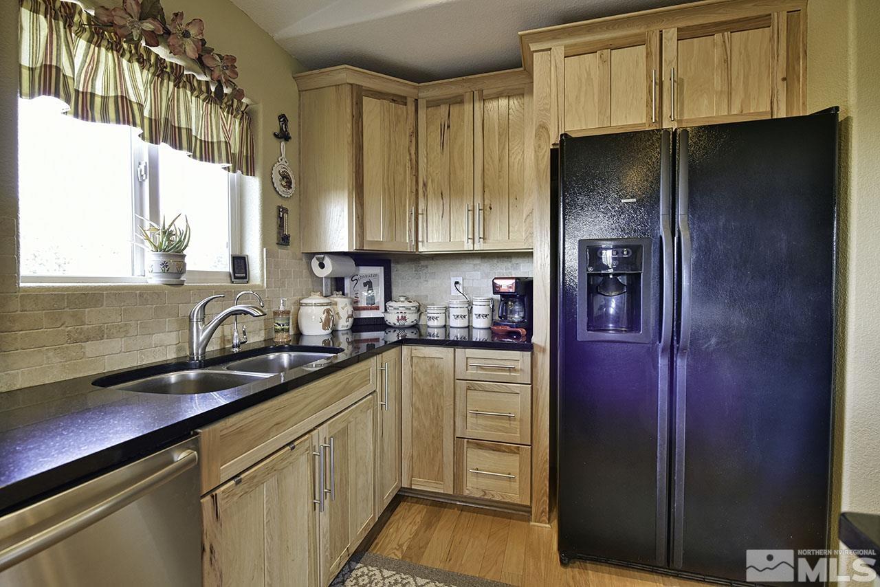 1597 Bonanza Road Reno, NV 89521 - Photo 16 of 28 a kitchen with granite countertop a refrigerator and a sink