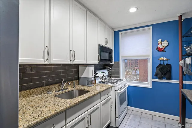 a kitchen with stainless steel appliances granite countertop a sink stove and cabinets