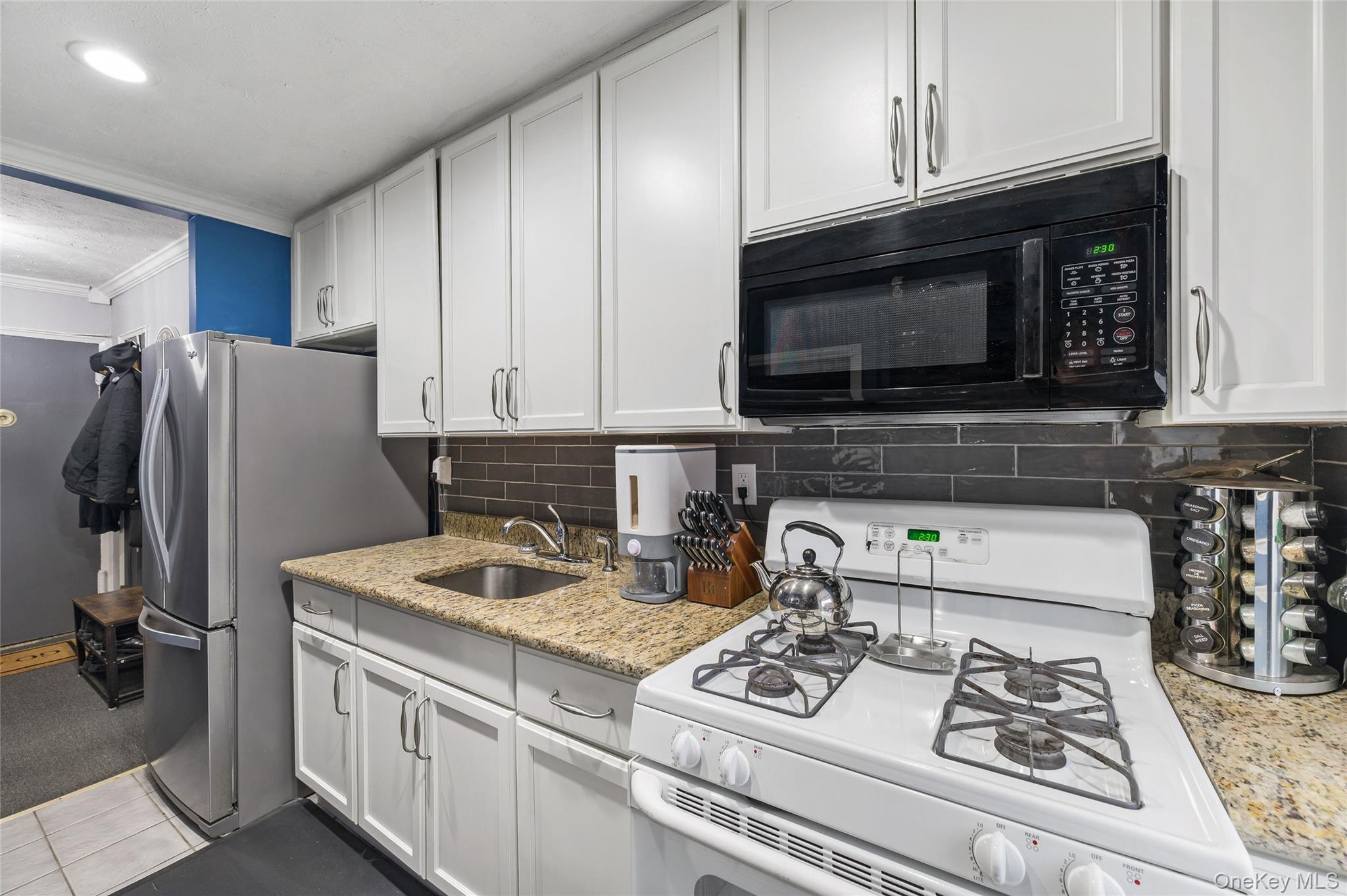 365 Bronx River Road, Unit 7C Yonkers, NY 10704 - Photo 9 of 13 a kitchen with stainless steel appliances granite countertop a stove refrigerator and microwave