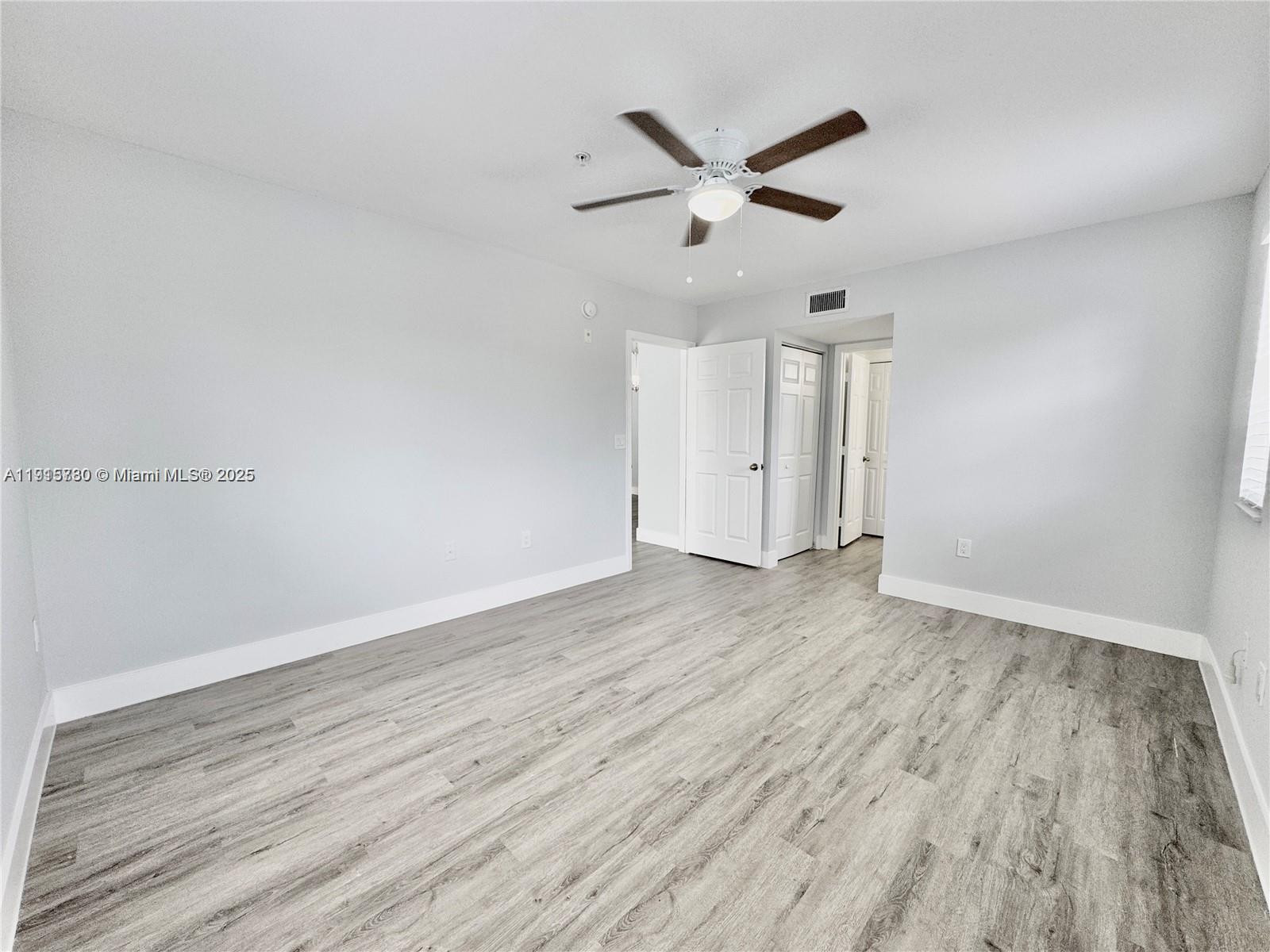 677 Southwest 111th Avenue, Unit 303 Pembroke Pines, FL 33025 - Photo 11 of 19 an empty room with wooden floor and windows