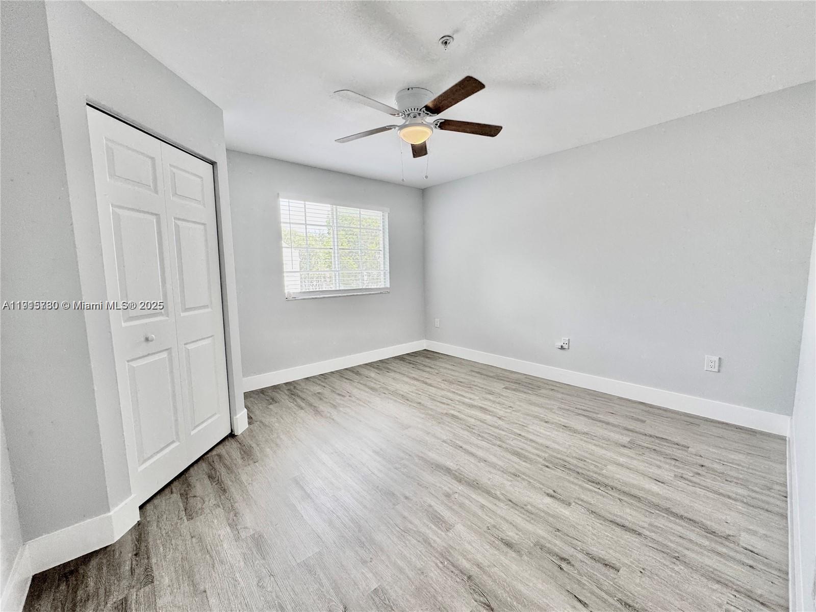 677 Southwest 111th Avenue, Unit 303 Pembroke Pines, FL 33025 - Photo 13 of 19 wooden floor in an empty room with a window