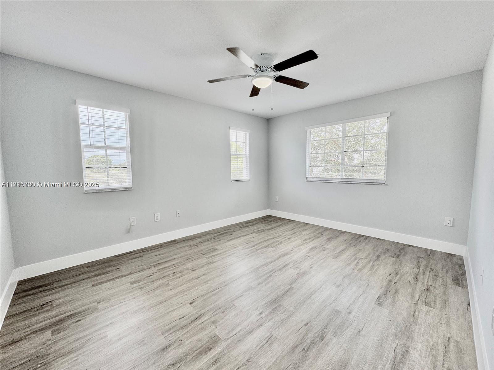 677 Southwest 111th Avenue, Unit 303 Pembroke Pines, FL 33025 - Photo 10 of 19 a view of an empty room with wooden floor and a window