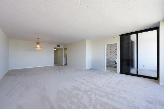 an empty room with closet and windows