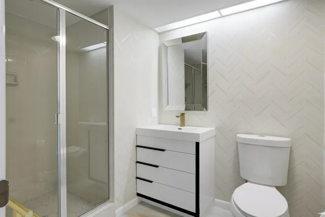 a bathroom with a toilet a sink and mirror