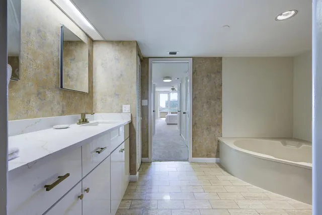 a bathroom with a tub sink shower and a mirror