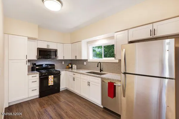 a kitchen with stainless steel appliances granite countertop a refrigerator sink and stove
