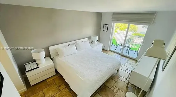 a bed sitting in a bedroom next to a window
