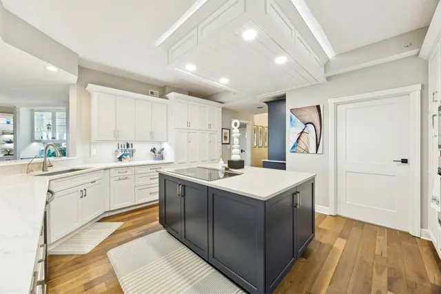 a kitchen with kitchen island a sink appliances and cabinets