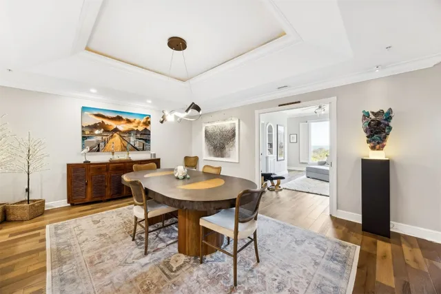 a kitchen with stainless steel appliances kitchen island granite countertop a refrigerator a stove and a sink with wooden floor