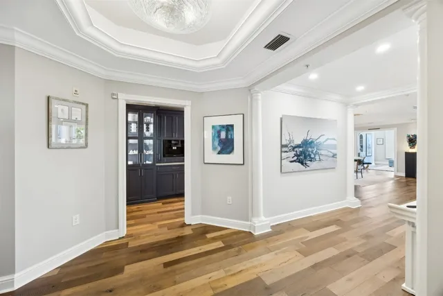 a view of a hallway with wooden floor and windows