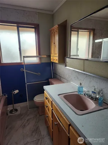 a bathroom with a sink a toilet and mirror
