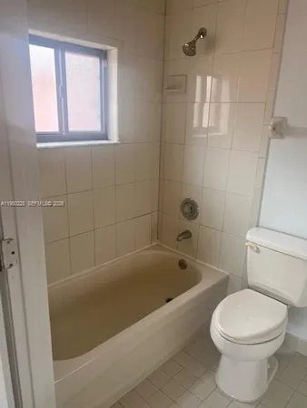 a bath room with a toilet and a bath tub