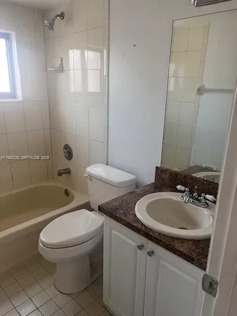 a bathroom with a granite countertop toilet a sink and a bathtub