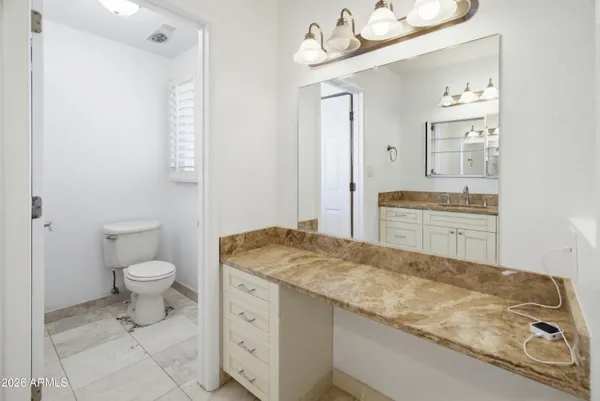 an empty room with wooden floor chandelier fan and windows