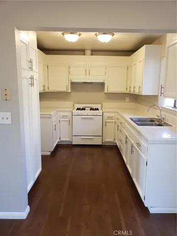 a kitchen with granite countertop white cabinets and white appliances