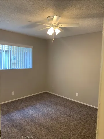a view of a livingroom with a ceiling fan and window