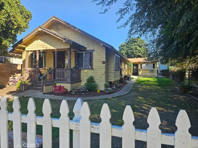 a front view of house with yard and trees around