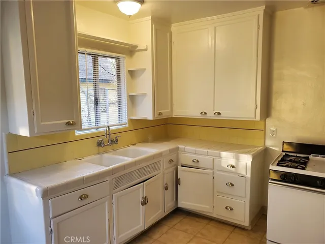 a kitchen with granite countertop white cabinets and white appliances