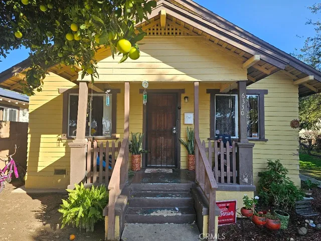 a view of a house with large windows and flower plants