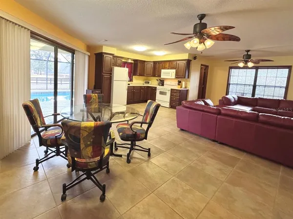 a living room with stainless steel appliances kitchen island granite countertop furniture and a flat screen tv