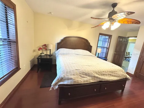 a spacious bedroom with a bed and wooden floor