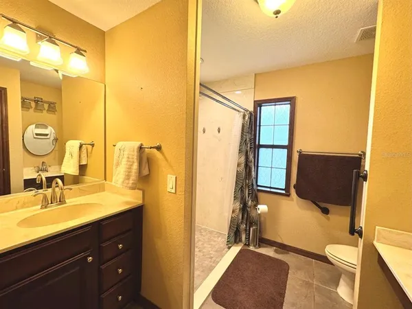 a bathroom with a shower sink vanity and mirror