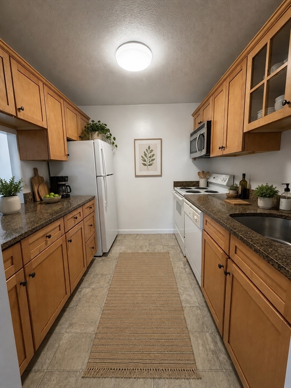 2 Victory Road, Unit 38 Lynn, MA 01902 - Photo 4 of 10 a kitchen with stainless steel appliances granite countertop a sink stove and cabinets