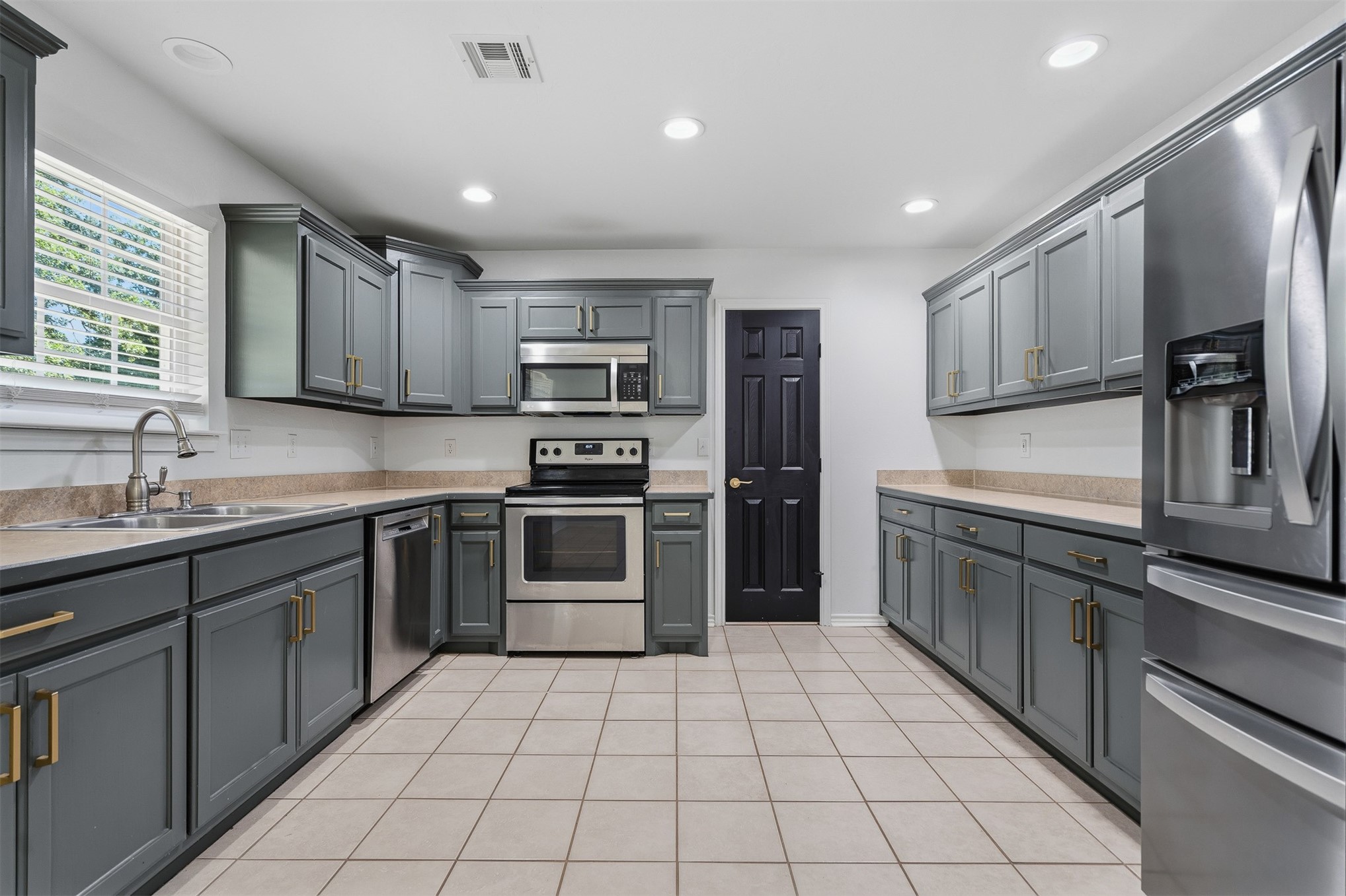 831 Barrons Ridge Wilson, OK 73463 - Photo 7 of 47 Kitchen featuring grey shaker-style cabinetry with gold-tone hardware, stainless steel appliances, light-toned countertops, and tiled flooring