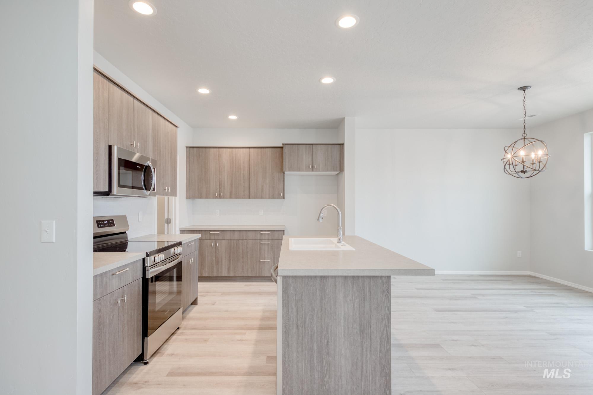 13740 Judson Street Caldwell, ID 83607 - Photo 7 of 23 Kitchen with stainless steel appliances, modern cabinets, recessed lighting, decorative light fixtures, and a kitchen island with sink