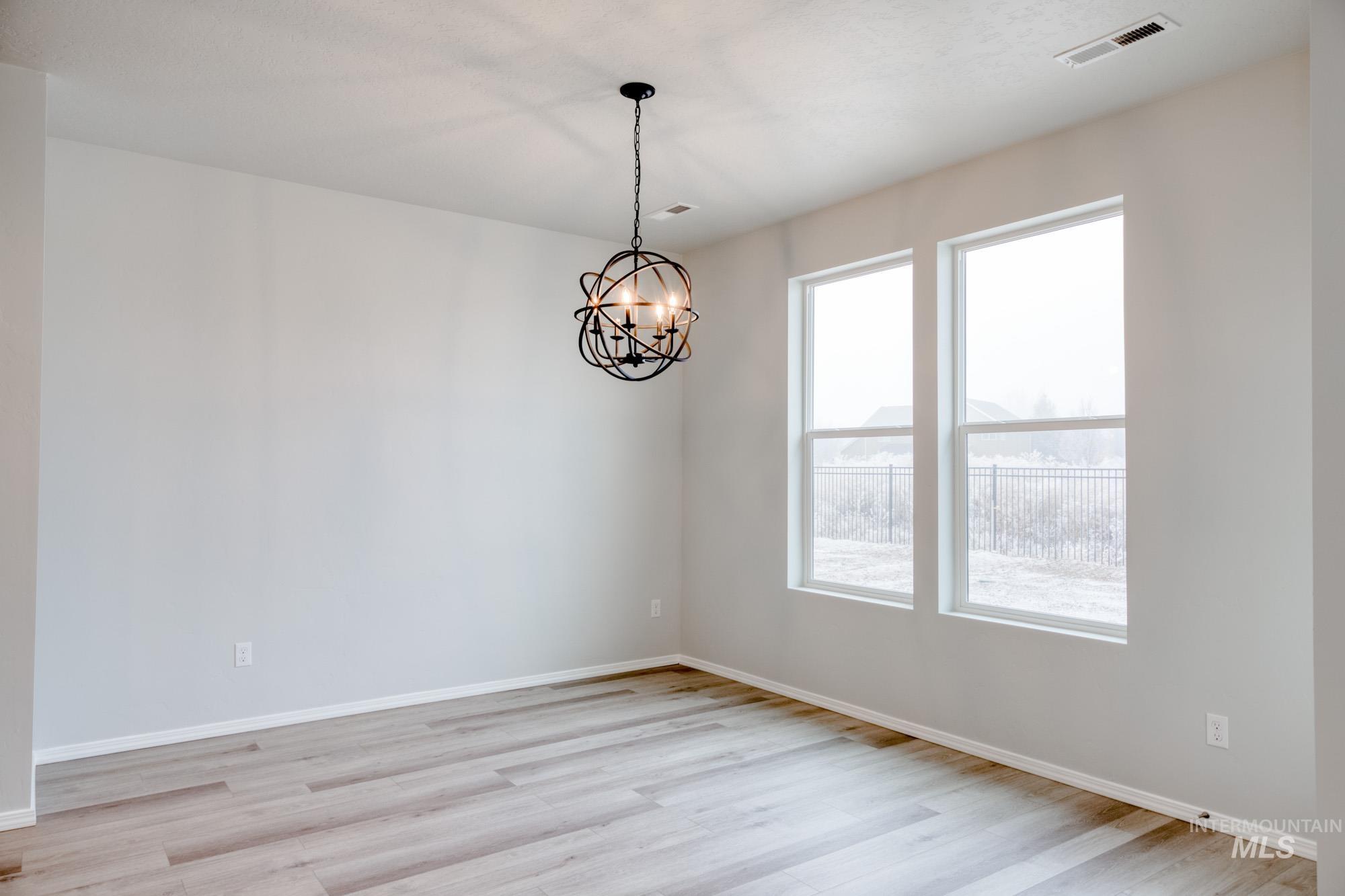 13740 Judson Street Caldwell, ID 83607 - Photo 8 of 23 Unfurnished room with light wood finished floors and a chandelier