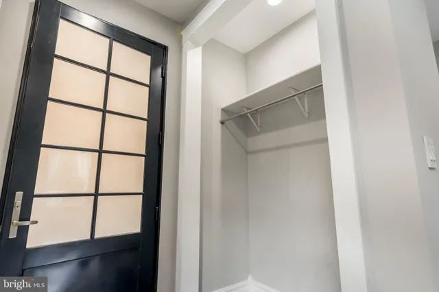 an empty room with wooden floor chandelier and windows
