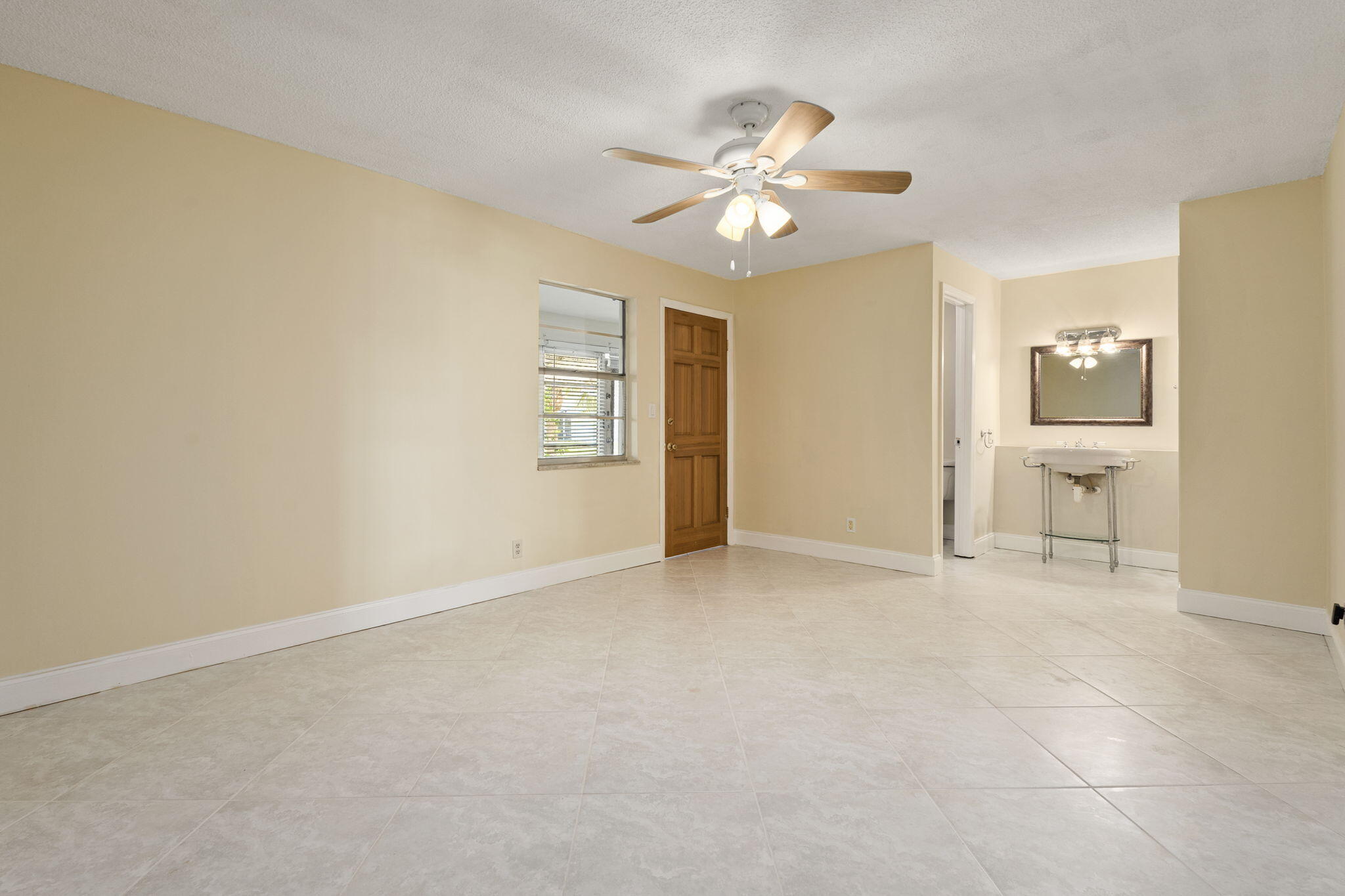 311 Colony Lane, Unit C Fort Pierce, FL 34982 - Photo 11 of 24 an empty room with windows and fan