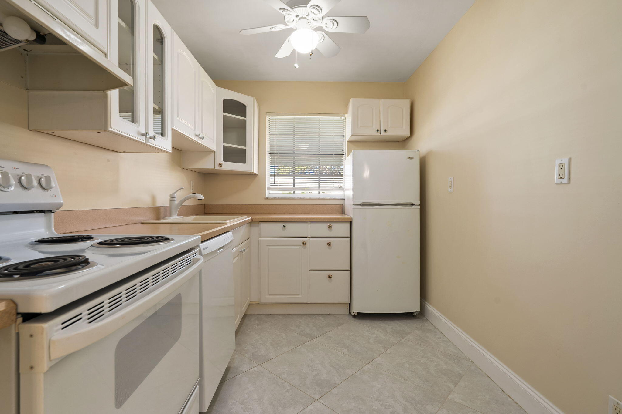 311 Colony Lane, Unit C Fort Pierce, FL 34982 - Photo 5 of 24 a kitchen with white cabinets and white appliances