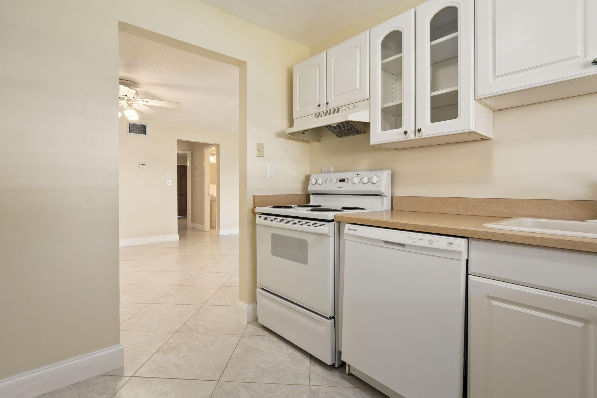 311 Colony Lane, Unit C Fort Pierce, FL 34982 - Photo 7 of 24 a kitchen with white cabinets and white appliances