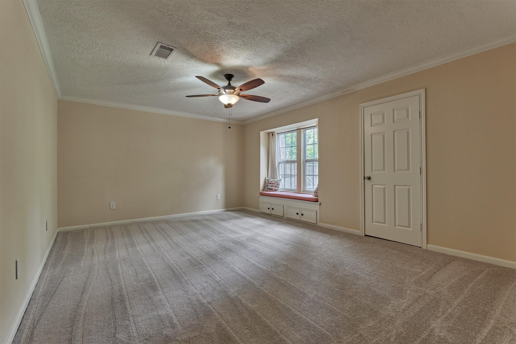 8 Wind River Court Conroe, TX 77384 - Photo 17 of 50 Secondary bedroom is generous in size and features new carpet, window seat, and crown molding. Flex room could also be used as a game room or home gym.