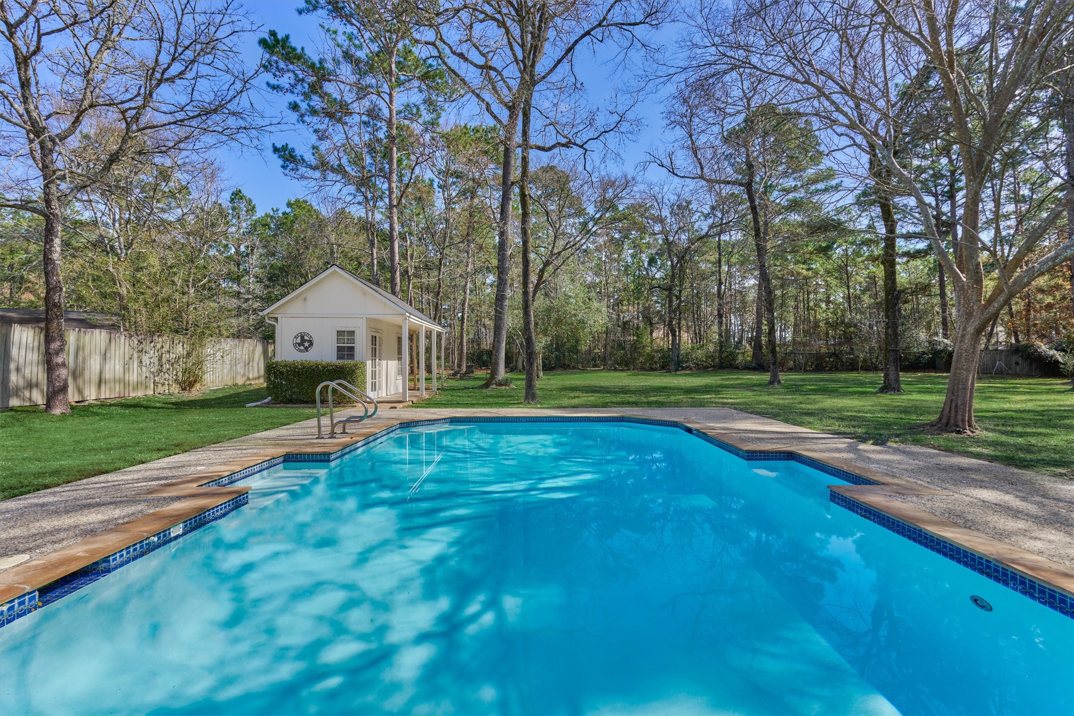 8 Wind River Court Conroe, TX 77384 - Photo 34 of 50 Mature trees provide opportunities for shade alongside this sparkling pool! Removable pool security fence included.