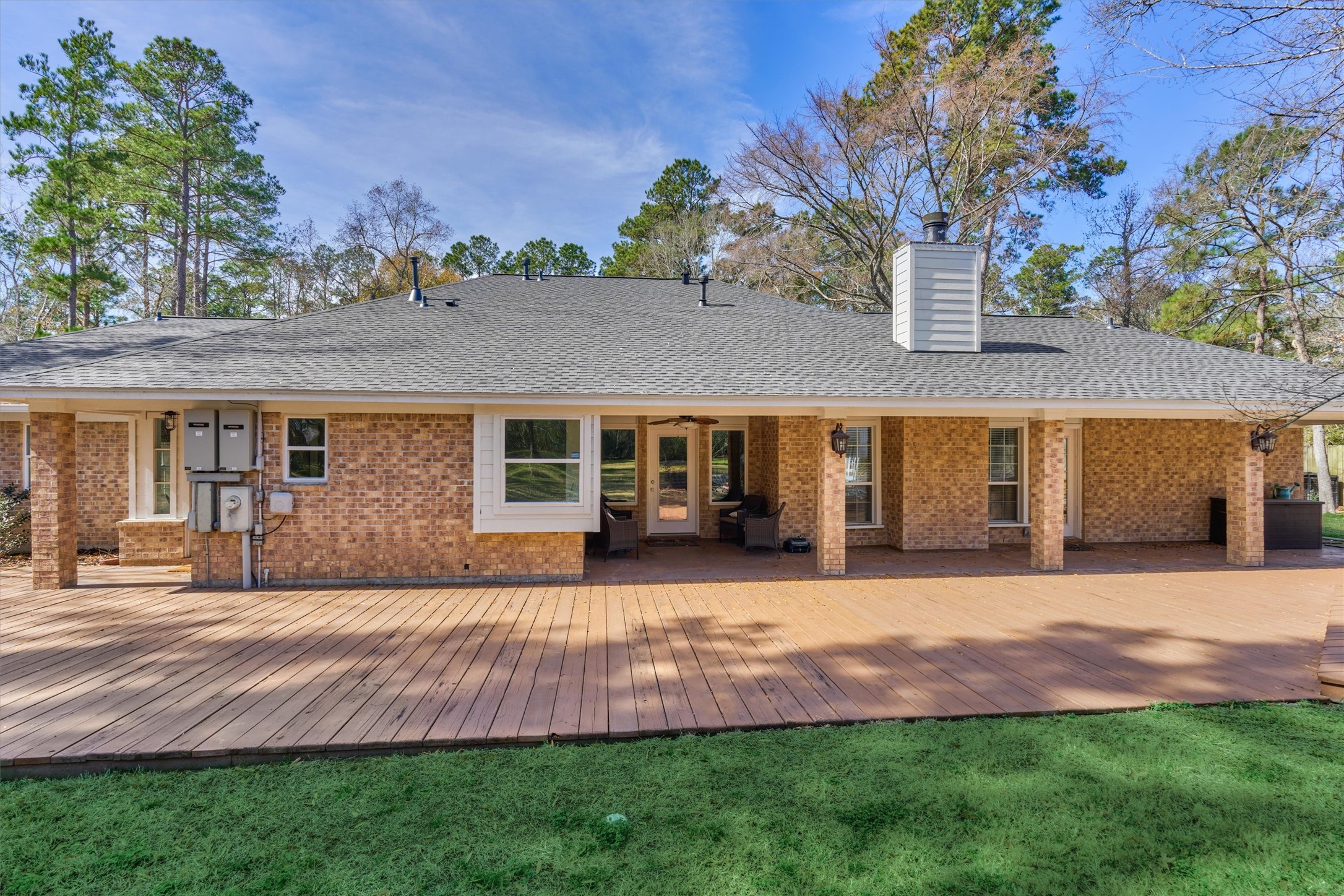 8 Wind River Court Conroe, TX 77384 - Photo 37 of 50 Covered patio runs the length of the home alongside this sprawling deck for unlimited outdoor possibilities!