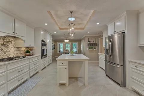 a kitchen with kitchen island a sink stainless steel appliances and cabinets