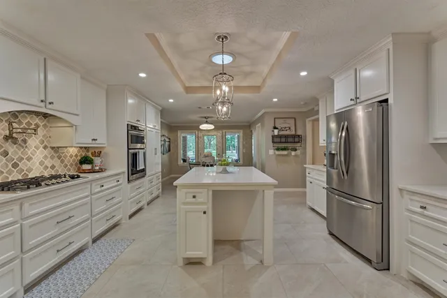 a kitchen with kitchen island a sink stainless steel appliances and cabinets