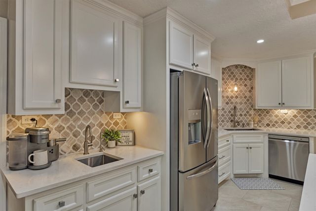 a kitchen with a white center island stainless steel appliances cabinets and a counter top space