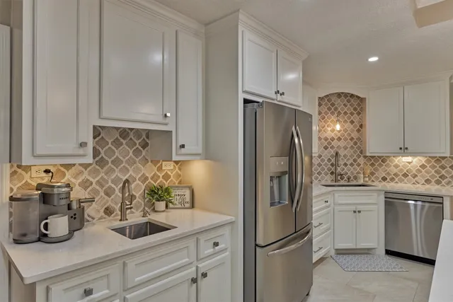 a kitchen with a white center island stainless steel appliances cabinets and a counter top space