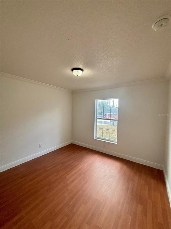 6605 Southwest 129th Loop Ocala, FL 34473 - Photo 12 of 21 a view of an empty room with wooden floor and a window